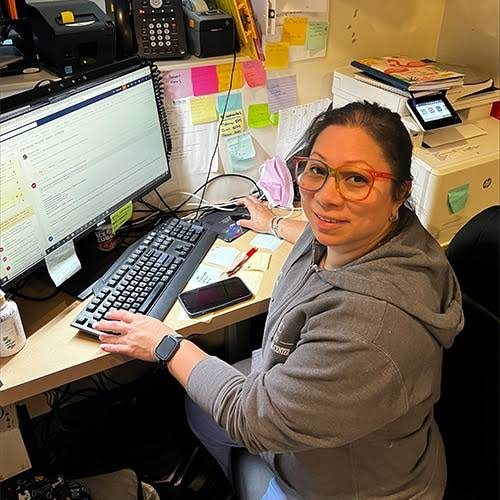Jessica Mejia at her desk, smiling